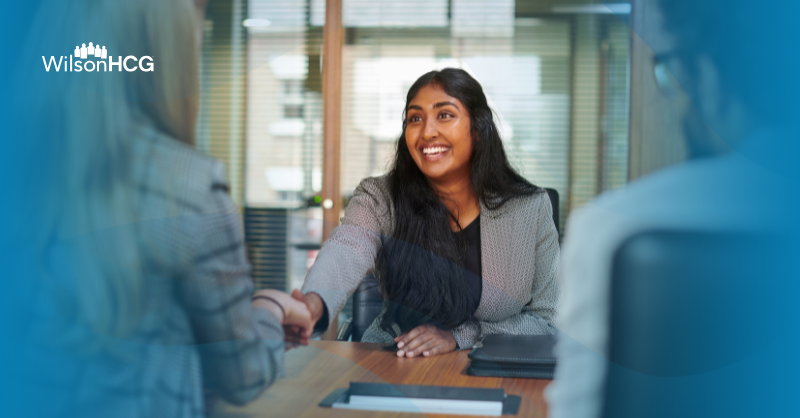 Employees in a modern office shaking hands and discussing business