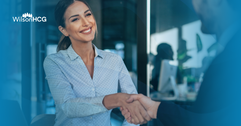 Businesswoman shakes hands with a male client.