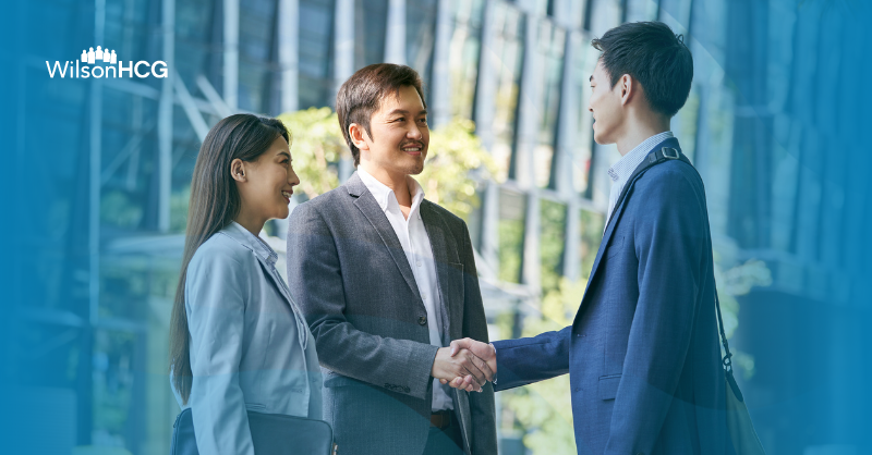 Three Asian businesspersons in an urban landscape.