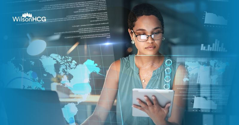 African American software engineer looking at tablet, laptop and data.