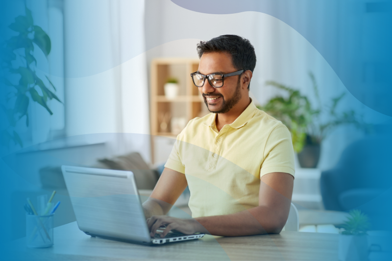 Happy Indian Man In Glasses With Laptop Computer Working At Home Office